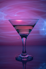 a glass of martini on a purple background