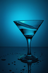 a glass of martini on a blue background