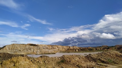 blue sky over inert land and contaminated water