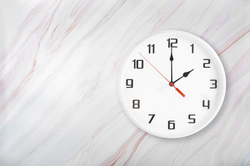 White wall clock on natural marble background