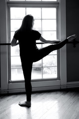 Fototapeta na wymiar Black & White photo of young ballet dancer at big window and bar.