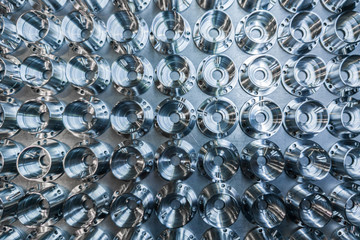a batch of shiny metal cnc aerospace parts production - close-up flat lay with selective focus for industrial background
