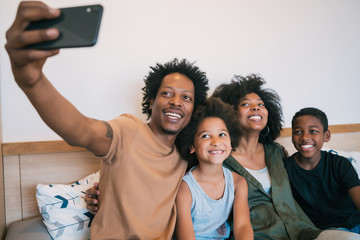 Family taking selfie together with phone at home.