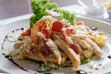 Close up view on Caesar salad served in a white plate on the table fresh with some parsley
