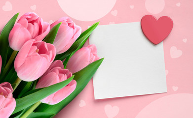 Valentine Mother's day greeting card with pink tulips and blank paper note with heart on pink background.