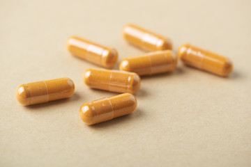 Turmeric capsules. Bright paper background. Close up. 