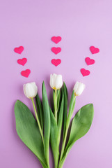 Set of three white tulips with hearts on pink background.