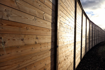Long wooden fence lit by sunlight