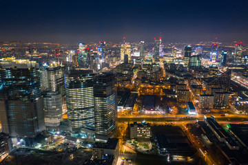 Warsaw-Poland 04. December. 2019. Aerial view of luminous high-rise buildings of the business center with lighted windows located in Warsaw against the evening sky. 