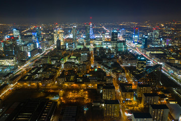 Fototapeta na wymiar Warsaw-Poland 04. December. 2019. Aerial view of luminous high-rise buildings of the business center with lighted windows located in Warsaw against the evening sky. 