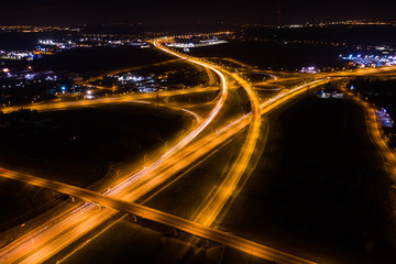 Fototapeta na wymiar Drone shot Above of elevated road junction and traffic an important transport at night. Aerial view of a highway with cars at night. Poland. 