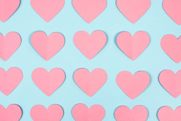 Close-up of pink paper hearts on blue background. Pink paper hearts seamless background. Flat lay. Top view