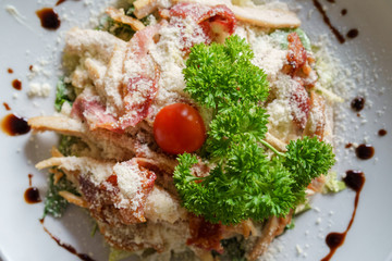 High angle top view on Caesar salad served in a white plate fresh with some parsley