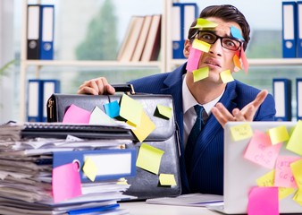 Businessman with reminder notes in multitasking concept