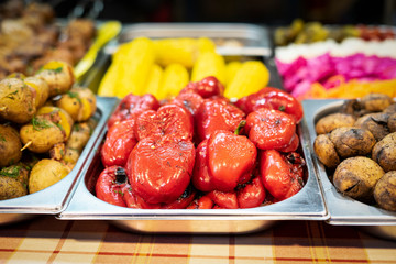 Baked red bell pepper and grilled potatoes at a street food festival.