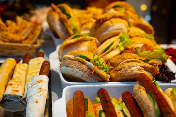 Fast food hamburgers and sausages in pastry at a street food festival.