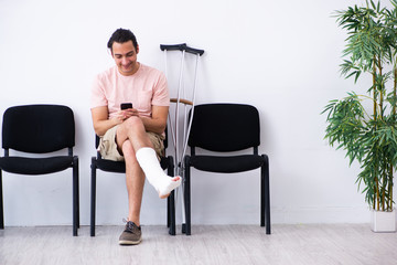 Young injured man waiting for his turn in hospital hall