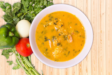Braised Fish Fillet or Stew fish. Cooked fish made with tomatoes, onions, peppers and coriander. Wood Background.
