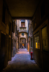 Fototapeta na wymiar Narrow dark alleys of Venice during the day