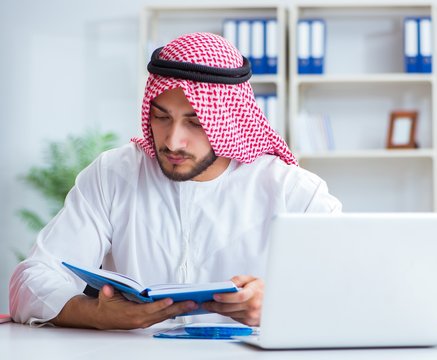 Arab businessman working in the office doing paperwork with a pi
