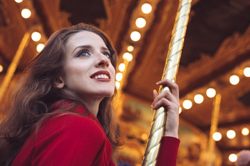 Portrait of a beautiful young girl in front of a carousel horse © danieleorsi
