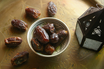 Dates fruits in a bowl on ethnic metal plate. Ramadan kareem.