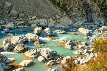 The brilliant flowing turquoise water in the Hooker Valley river rapids, Aoraki Mt Cook National Parkin the Southern Alps of New Zealand