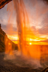 beautiful sunset at the Seljalandsfoss waterfall in Iceland. View from behind the water