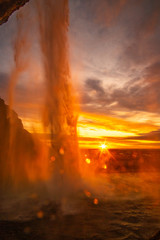 Fototapeta na wymiar beautiful sunset at the Seljalandsfoss waterfall in Iceland. View from behind the water