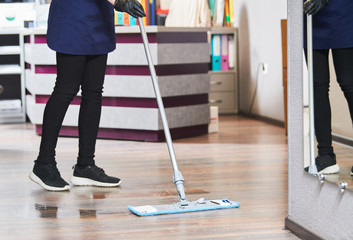 cleaning service. wiping office floor with mop