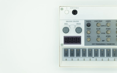 White analog synthesizer sampler with knobs and keys. Audio equipment for musical production. Drum machine. White background. Music concept.