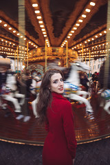 Obraz premium Portrait of a beautiful young girl in front of a carousel horse