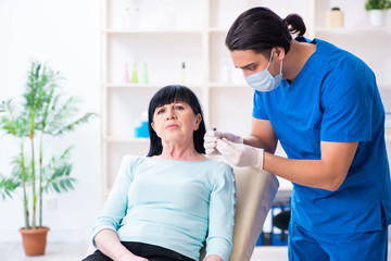 Fototapeta premium Old woman visiting male doctor for plastic surgery