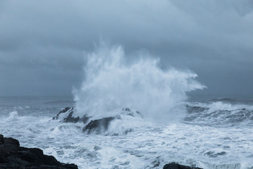 Wave crashing over rocks in Iceland coast