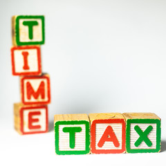 Tax Time -  wooden block. Shallow depth of field, selective focusing. On white background