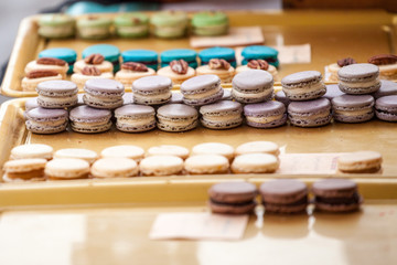 Obraz na płótnie Canvas Lavander flavored purple macarons on display in a French pastry shop among other macaroons. Macaron is a traditional biscuit and cake from France, a symbol of gastronomy