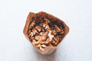The daily rate of nuts for an adult in a paper bag on a white background. The benefits of walnut for the brain.