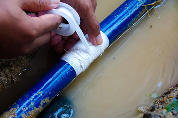 Residential water pipe break and repair with white tape.