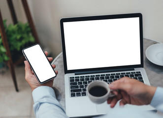 mockup image blank screen computer,cell phone with white background for advertising text,hand man using laptop texting mobile contact business search information on desk in cafe.marketing,design