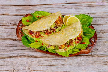 Soft flour tortillas stuffed with lettuce, meat and cheese on wooden background.