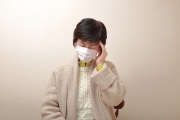 middle aged woman wearing a mask and catching a cold