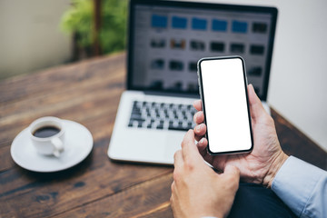 Mockup image blank white screen cell phone.man hand holding texting using mobile on desk at coffee shop.background empty space for advertise text.people contact marketing business,technology 