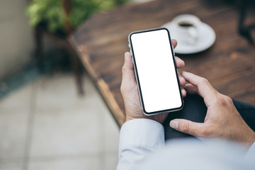 Mockup image blank white screen cell phone.man hand holding texting using mobile on desk at office.background empty space for advertise text.people contact marketing business,technology 