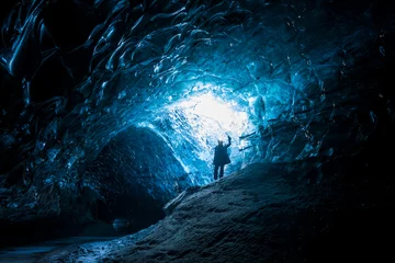 Foto op Aluminium Female explorer standing inside ice cave tunnel, Iceland © jamenpercy