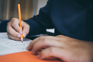 high school,university student study.hands holding pencil writing paper answer sheet.sitting lecture chair taking final exam attending in examination classroom.concept scholarship for education abroad