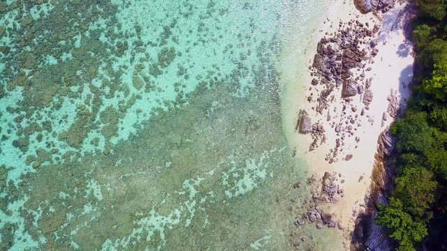 Aerial drone shot of beautiful paradise sand with rock beach with clear turquoise sea. Summer and travel vacation concept. Overhead shot.