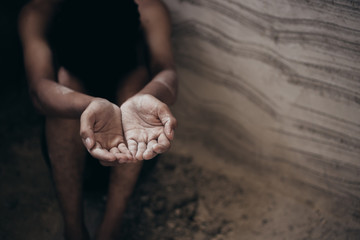 poor child or beggar begging you for help sitting at dirty slum. concept for poverty or hunger people,human rights,donate and charity for underprivileged children in third world 