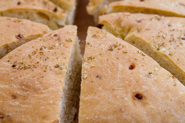 Fresh Focaccia bread with rosemary; focaccia loaf sliced into triangles