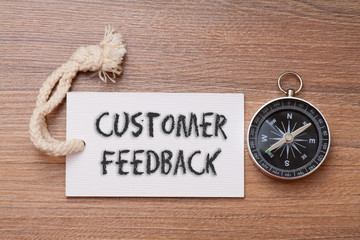Customer feedback - business tips handwriting on label with compass