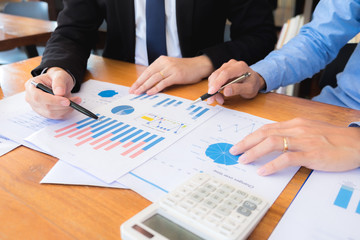 Sitting and working, consulting and suggesting work, checking work reports with a calculator in a business office.